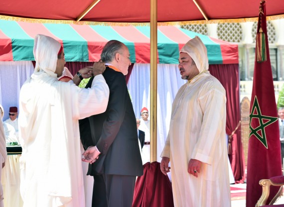Photo : Sa Majesté le Roi Mohammed VI élevant M. Jean-Paul Carteron, Consul Honoraire de Bulgarie, au grade de Commandeur de l'Ordre du Ouissam el Alaoui. 